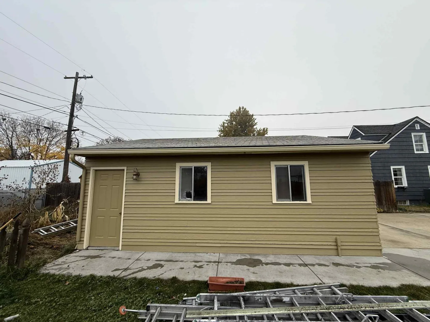 Finished tan house exterior repaint with white window trim