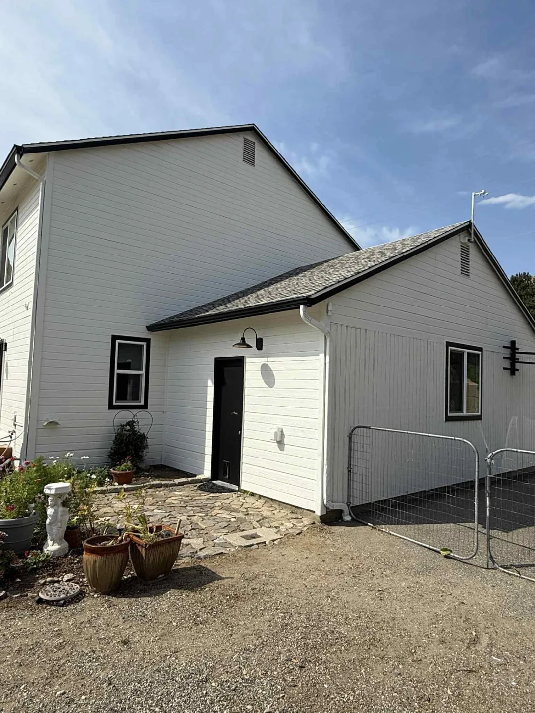 White house exterior with a black door and dark roof trim