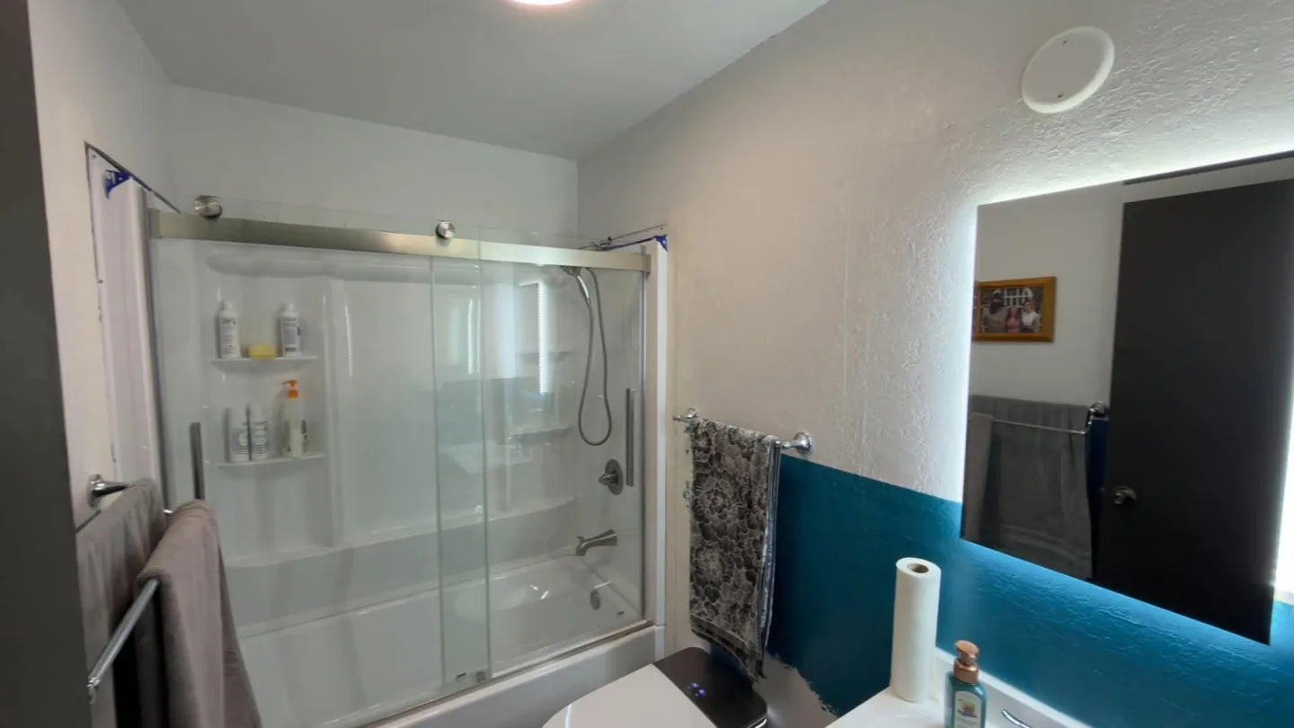 Repainted bathroom with light walls and a glass shower